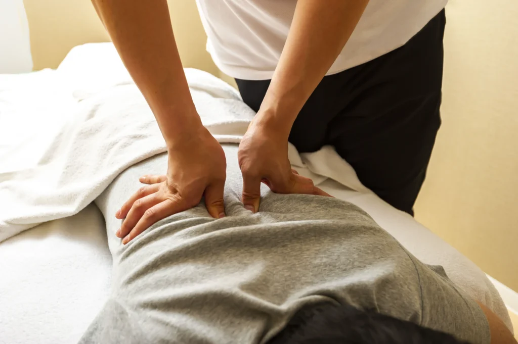 massage therapist massaging a patient's back to reduce back pain